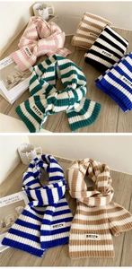 Detail of soft striped knit scarf with minimalist BRICK label and thick texture