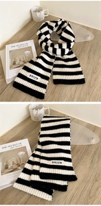 Close-up of thick striped knit scarf with a white BRICK label on a wooden desk