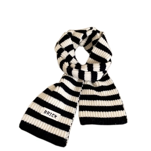 Classic black and white striped knit scarf with a woven label in a soft ribbed texture