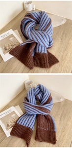 Close-up of blue and brown striped knit scarf texture with ribbed edges on wooden table