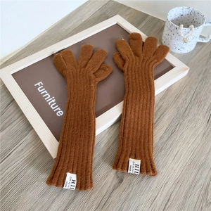 Detailed texture of brown ribbed knit gloves featuring a stylish white woven logo patch