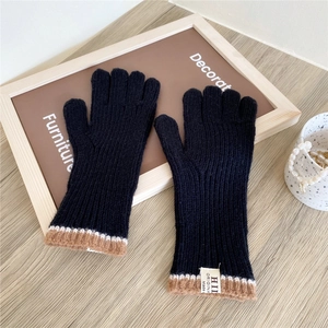 Close-up of black knitted touch screen gloves with ribbed texture and striped wrist cuff