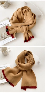 Detail of camel knit scarf with contrast red stitching and premium brand woven label