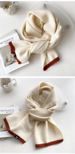 Close-up of thick bicolor knit scarf with black logo label and rib-knit finish