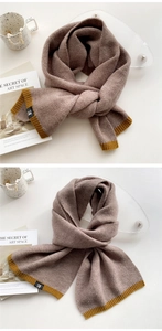 Macro view of thick knit scarf with brown and yellow color blocking and letter tag