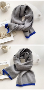 Close-up of thick grey knit scarf with blue ribbed edges and H logo label detail