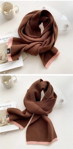 Detail of two-tone knit scarf showing brown and pink ribbed edges with woven brand label
