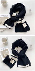 Gros plan de l'écharpe en tricot à rayures noires et blanches avec écusson de marque
