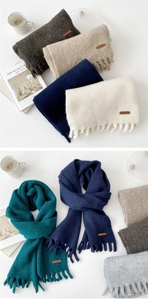 Detail shot of solid color thick scarves with short tassels and leather label accents