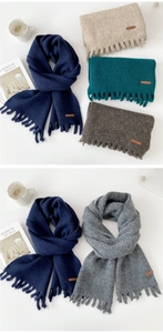 Detailed arrangement of thick knit scarves with short tassels and leather label details