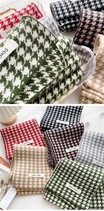 Detail of soft knit houndstooth scarves in multiple colors with classic brand labels