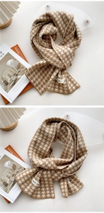 Detailed close-up of brown houndstooth knit scarf with logo label and cozy winter textures