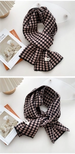 Detailed view of pink and black houndstooth knit scarf with a minimalist woven label