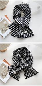Detail of classic houndstooth knit scarf with brand label and soft woven texture