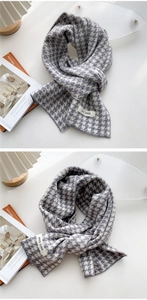 Detail showing the thick knitted houndstooth pattern and brand label of the winter scarf