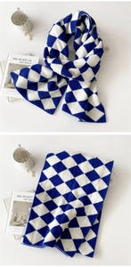 Close-up of blue and white diamond pattern knit scarf with soft wool texture
