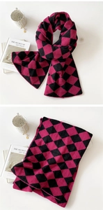 Close-up of pink and black argyle knit scarf with detailed stitching and soft texture