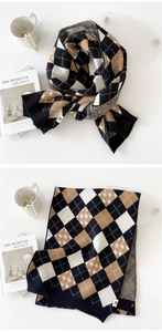 Détail d'écharpe en maille à losanges avec motifs d'étoiles et étiquette de marque