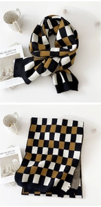 Détail de l'écharpe en maille à carreaux noir, blanc et ocre avec bords côtelés