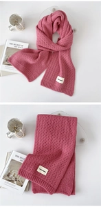 Detail of rose pink hollow knit scarf featuring Durian Freedom woven label on soft texture