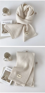 Detailed texture of cream knit scarf with waffle pattern and Durian Freedom woven label