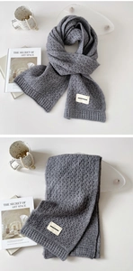 Detail of dark grey knitted scarf with soft texture and Durian Freedom woven label