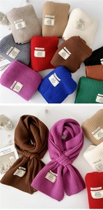 Macro detail of ribbed knit scarves in assorted colors with stitched brand labels