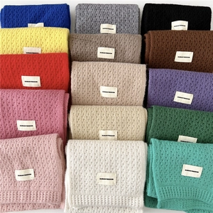 Knitted scarf collection in 14 colors featuring minimalist texture and brand labels