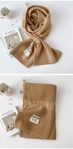 Detail of warm khaki knit scarf showing soft waffle texture and materials care label