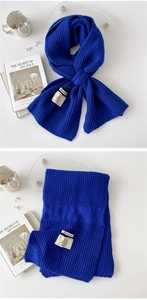 Detail of blue ribbed knit scarf showing texture and material label with 22% cashmere blend