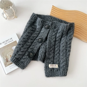 Close-up of dark grey knitted neck warmer with three buttons and brand label