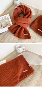 Detailed view of caramel wool scarf with brand tag showing 100% wool material texture