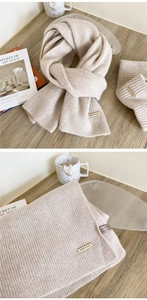 Close-up of oatmeal wool scarf showing vertical knit texture and metal brand tag
