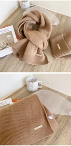 Detail of camel wool scarf and hat set with 100% wool label and knit texture