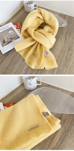 Close-up of bright yellow 100% wool knit scarf featuring textured vertical ribbed patterns