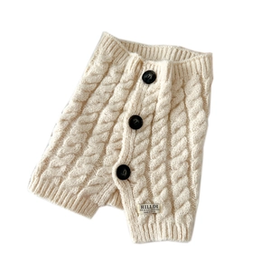 Cream knit button neck warmer with cable pattern and three decorative black buttons