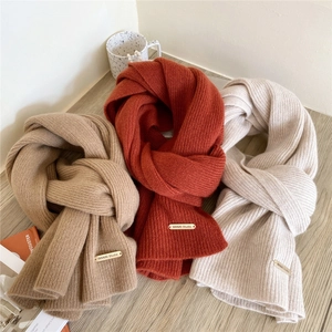 Thick knitted wool scarves in khaki, rust red and cream white with metal brand tags