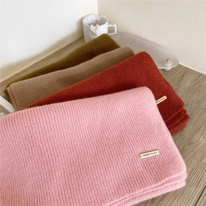 Thick knitted wool scarves in pink, red, and olive green with ribbed texture