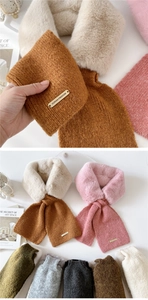 Detail of plush faux fur and knit scarves with gold metal plate in multiple colors