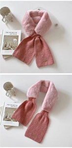 Close-up of pink faux fur and knit scarf with a premium metal logo plate detail