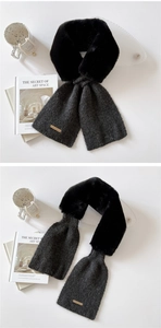 Detail of plush black faux fur and dark grey knit scarf with a small metal tag
