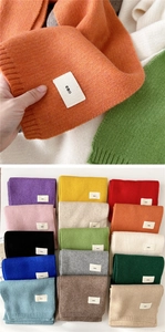 Macro detail of knit scarf texture with emo brand tag and multi-color palette options