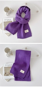Detail of purple knit scarf with rib edges and emo fabric label for winter warmth