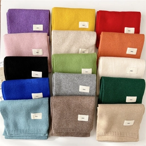 Solid knit scarves in 15 vibrant colors with minimalist emo woven tags and ribbed edges