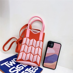 Detailed knit texture of mini phone bag in orange and pink geometric arrow patterns
