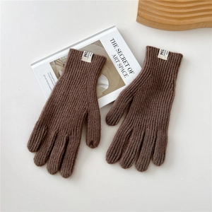 Detail view of dark brown knitted touch-screen gloves with ribbed texture and fabric tag