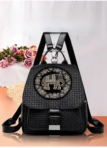 Detail of black faux leather backpack featuring a crystal elephant motif and metal buckle