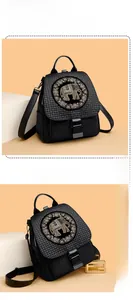 Detailed view of woven black backpack featuring a sparkling elephant motif and metal clasp
