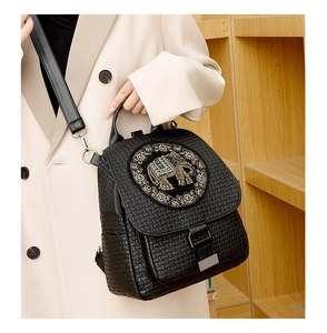 Detail of black faux leather backpack with sparkling rhinestone elephant pattern motif