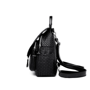 Minimalist black embossed leather backpack with silver hardware for women in a side view
